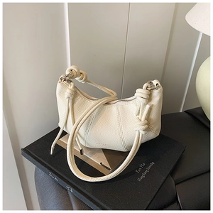 Detail der cremeweißen Hobo-Tasche aus Leder mit Lychee-Muster und Knoten am Schultergurt