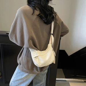 Back view of model wearing a minimalist beige canvas crescent bag for daily commute