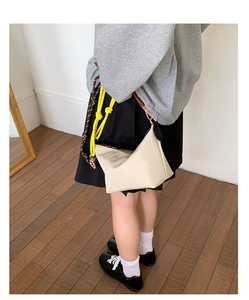 Minimalist cream shoulder bag with neon yellow rope detail and slim brown leather strap
