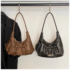 Detail of vintage pleated hobo bag with MKMX logo and distressed PU leather texture