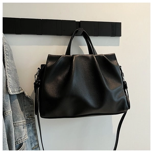 Close-up detail of black pleated leather texture on a stylish bucket bag with silver metal hardware
