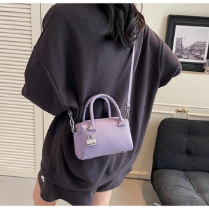 Close-up of purple litchi grain leather mini Boston bag with silver lock and shoulder strap