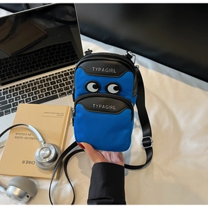 Close-up of blue nylon crossbody phone bag with cartoon eyes and dual zipper detail