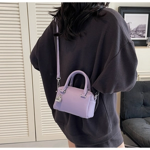 Detail of lavender litchi pattern leather mini pillow bag with silver lock charm