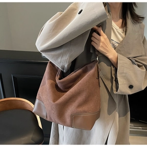 Detail view of large dark brown matte shoulder bag showing texture and reinforced leather edges