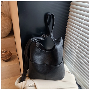 Detailaufnahme der schwarzen Beuteltasche aus genarbtem Leder mit Tasche und breitem Gurt