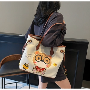 Detailed macro view of the white pebble leather texture and cute bear print on tote bag