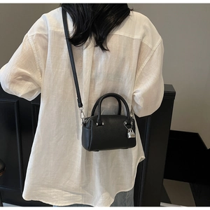 Black pebbled leather Boston handbag with silver padlock worn over the shoulder