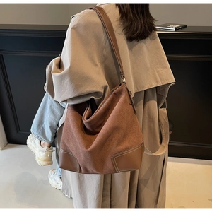 Vintage brown large capacity shoulder tote bag in suede and leather worn with a trench coat