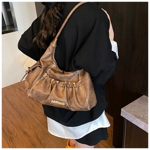 Close-up of vintage brown pleated hobo bag with textured PU leather and logo detail