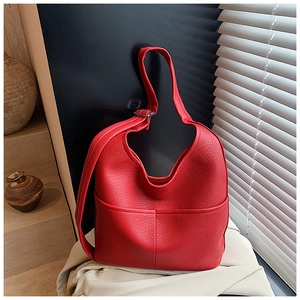 Detailansicht einer roten Ledertasche mit Kieselmaserung und dekorativen Kreuznähten