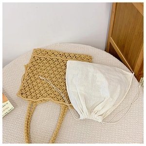 Close-up of handmade straw tote bag with a white canvas drawstring inner pouch