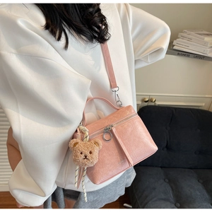 Pink pleated crossbody bag with a cute brown bear plush charm and silver ring zipper