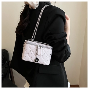 Detail view of pink quilted box bag with sparkling rhinestones and silver chain strap