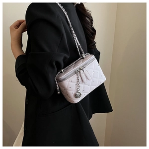 Close-up of light pink quilted chain bag with rhinestone decor and rose pendant detail