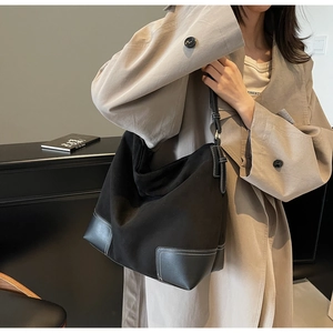 Detail view of black matte tote bag showing white contrast stitching and texture