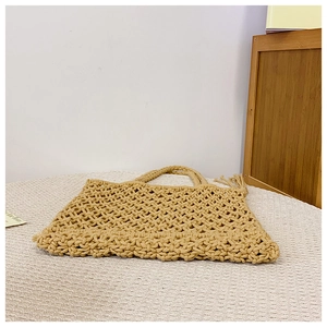 Macro detail of beige woven tote bag showing intricate handmade hollow diamond mesh pattern