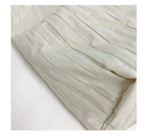 Dettaglio macro del tessuto in tela plissettata bianco crema con trama verticale della borsa