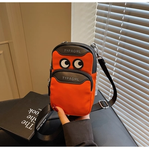 Detailed close-up of orange canvas phone bag with eye applique and double zipper pockets