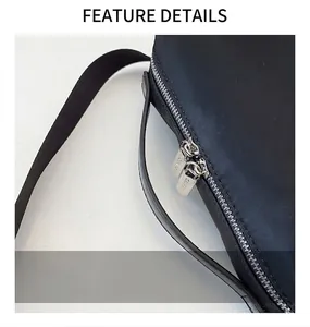 Détail du sac en nylon noir avec poignée en cuir lisse et fermetures éclair en métal argenté