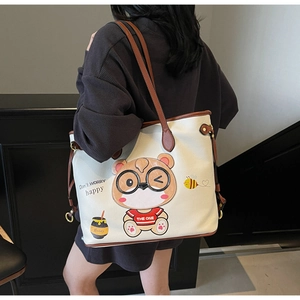 Close-up of cute cartoon bear print and honey embroidery on white leather tote bag