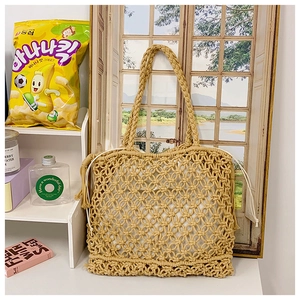 Detail of hand-woven straw tote bag featuring hollow mesh pattern and white drawstring lining