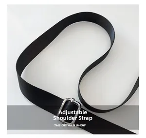 Gros plan sur la bandoulière réglable en nylon noir avec une boucle argentée