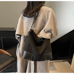 Detail of vintage matte black leather tote with white contrast stitching and wide strap