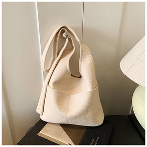 Detailansicht der cremeweißen Litschi-Lederstruktur einer minimalistischen Hobo-Bag