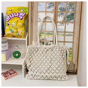 Detail of macramé woven tote bag with fringe edge and internal drawstring pouch