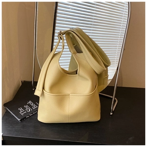 Detail der creme-gelben Beuteltasche mit Lychee-Prägung und feiner Nahtverarbeitung
