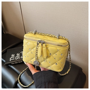 Detail of yellow quilted crossbody bag with white rhinestones and silver rose pendant