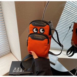 Close-up detail of cartoon big eyes design on bright orange nylon mini crossbody bag