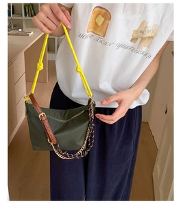 Olive nylon shoulder bag with yellow woven strap and leather buckle detail