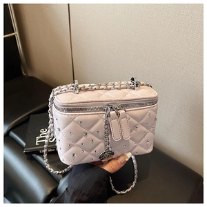 Detailed quilted leather box bag featuring crystal studs and a metal camellia pendant