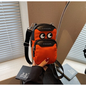 Detail of orange nylon phone bag with cartoon eyes embroidery and black leather trim