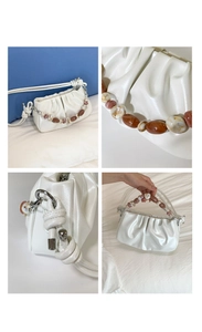 Detail of white pleated cloud bag with marble bead handle and silver hardware