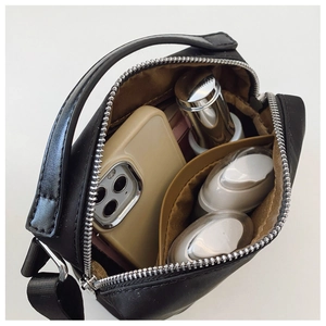 Détail de l'intérieur d'un sac bandoulière en nylon noir avec compartiments de rangement