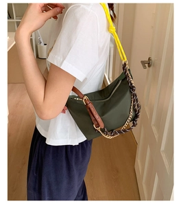Detail of army green nylon crescent shoulder bag with woven rope strap and gold metal chain