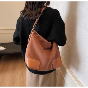 Detail showing the brown suede and leather splicing texture of this large tote bag