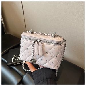 Detailed shot of pink quilted box bag with crystal embellishments and rose zipper pull
