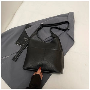 Detail der schwarzen Beuteltasche aus Leder mit Kieselmaserung und Außentaschen