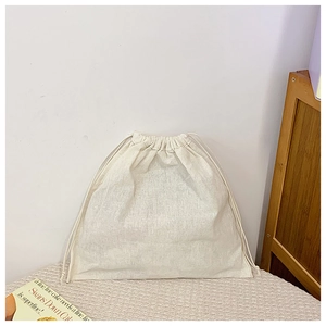 Detail of a beige linen drawstring pouch with natural texture for travel storage