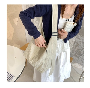 Dettaglio della borsa tote beige a pieghe con texture del tessuto e tracolla regolabile