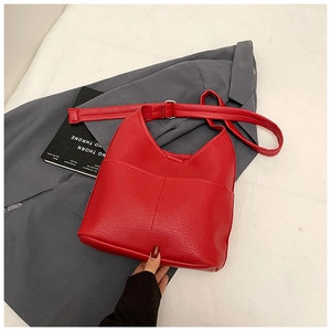 Detail der roten Eimertasche aus Kieselleder mit verstellbarem Gurt und Silberschnalle