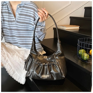 Detail of vintage pleated shoulder bag with MKMX logo and side pocket in black