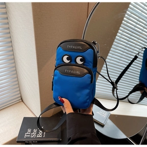 Close-up of blue nylon crossbody bag with cartoon eyes and multi-zipper detail