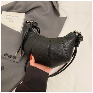 Detail der schwarzen Croissant-Tasche aus Kieselleder mit Knotengurt und Silberzipper