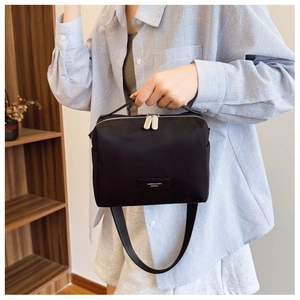 Détail du sac bandoulière en nylon noir avec doubles fermetures éclair et large sangle