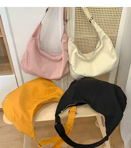 Detail showing four colored nylon crescent bags with minimalist heart patterns